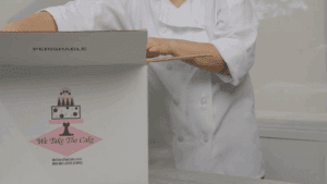 Baker preparing a frozen cake for delivery with dry ice handling it safely